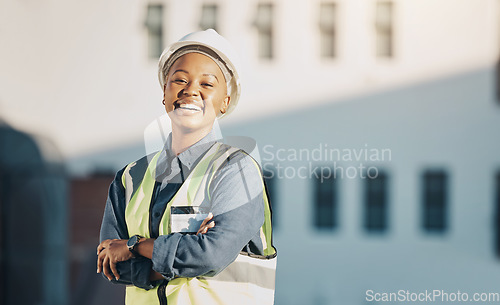 Image of Woman, construction worker and arms crossed portrait with a smile for engineering and building renovation job. Happy and African female employee on a industrial site outdoor for builder project