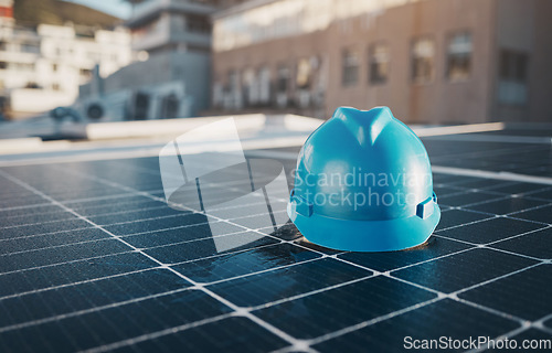 Image of Construction, building and a hat for solar panel on a roof for engineering or a sustainability job. Future, innovation and a helmet on a power development for a home, maintenance or renewable energy