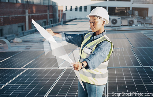 Image of Female engineer, solar panel blueprint or outdoor on roof for power, sustainability plan and energy development. Black woman, photovoltaic tech and reading on rooftop, building or electricity in city