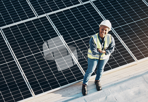 Image of Woman, solar panel construction and arms crossed portrait with a smile for engineering and green energy. Labor, happy and African female employee on industrial site outdoor for eco project from above