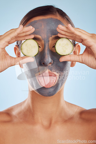 Image of Face mask, skincare and woman with beauty, cucumber and girl on a blue studio background. Portrait, female person and model with cosmetics, natural and aesthetic with hygiene, charcoal and self care