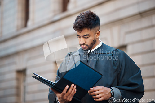 Image of Legal, research and a lawyer man reading documents on a city street in preparation of a court case or trial. Law, study and information with a young attorney getting ready for a judgement or verdict