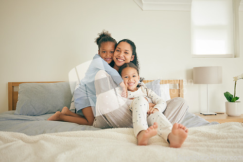 Image of Mom, children and hug on bed, portrait and happy family home with love, care and bonding together. Young kids, mother and daughter with embrace, bedroom and relax in pyjamas with smile in apartment