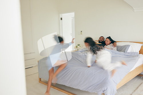 Image of Wake up, happy family and playing in bed in the morning, bond and having fun in their home together. Love, bedroom and children jumping on parents on the weekend, playful and energetic in their house