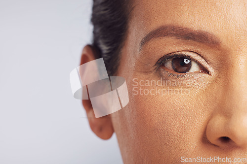 Image of Beauty, eye closeup and woman in studio with vision for cosmetics and mature skincare. Isolated, gray background and makeup with microblading portrait with dermatology and natural glow of model