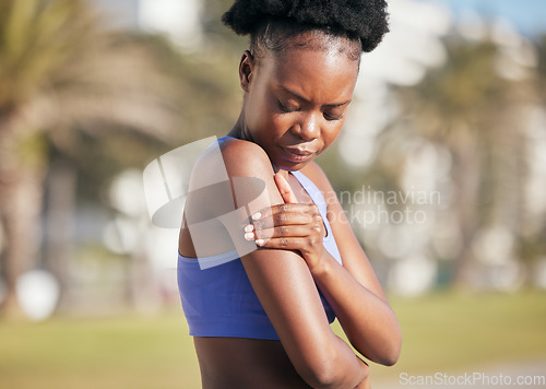 Image of Arm, pain and black woman in outdoor with injury from sport with strain from training accident. Cardio, muscle and shoulder inflammation with female athlete after exercise at park for workout.