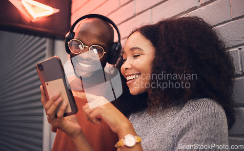 Image of Phone, music and headphones with a multicultural couple outdoor in a city together for dating. Love, mobile or streaming app with a man and woman bonding in an urban town while listening to the radio