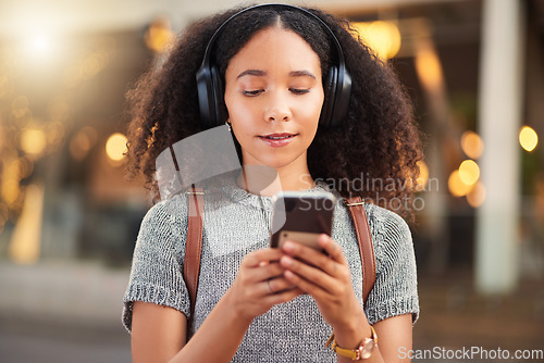 Image of City, headphones and woman with cellphone, typing and streaming music with happiness, social media or audio. Outdoor, female person or girl with a smartphone, mobile app or headset with sound or song