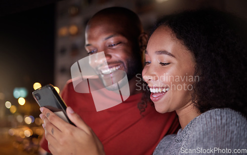 Image of .Phone, social media and funny couple in the city at night for love, freedom or fun together. Face, meme or mobile with a black man and woman in an urban town to enjoy nightlife while bonding.