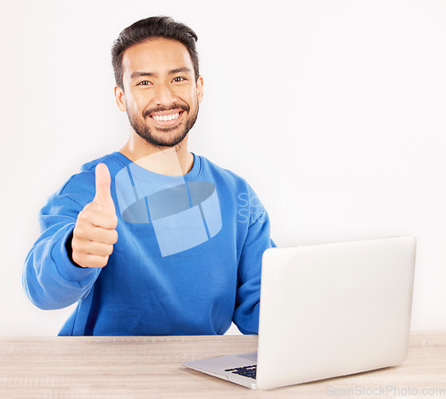 Image of Portrait, laptop and thumbs up with an IT support man at his desk in studio on a white background. Smile, thank you and yes with a happy male computer engineer working to finish or complete a task