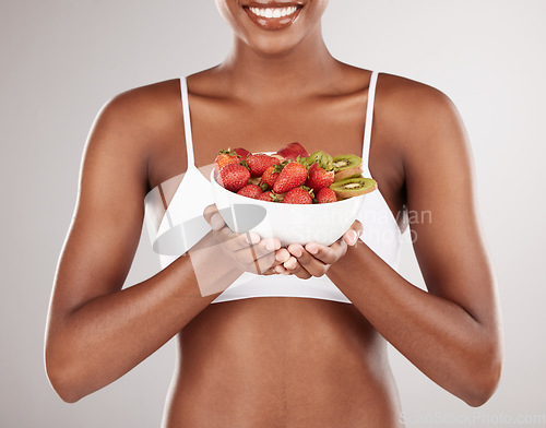 Image of Woman, hands and diet with bowl of fruit for natural nutrition against a white studio background. Closeup of female person holding organic strawberry, kiwi or salad to lose weight or healthy wellness