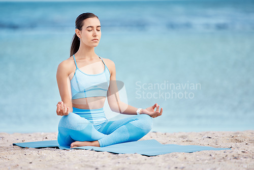 Image of Meditation, yoga and woman by beach for wellness, healthy body and zen energy by ocean for calm. Mindfulness, nature and female person with crossed legs for balance, training and meditate by sea