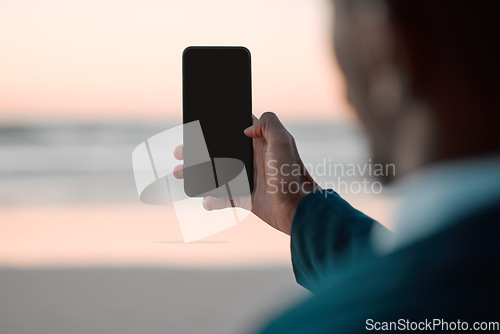 Image of Businessman, hands and phone screen on beach for communication, advertising or outdoor networking. Closeup of man with mobile smartphone app display mockup by ocean coast for business trip or travel