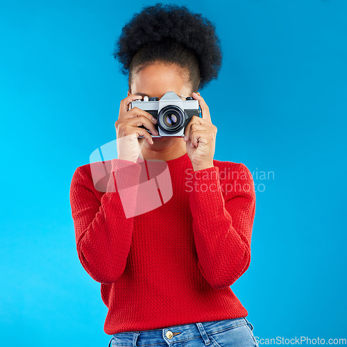 Image of Photographer woman, retro camera and studio for photoshoot, memory or magazine by blue background. Young journalist girl, vintage tech and lens for paparazzi, newspaper or work at content creator job