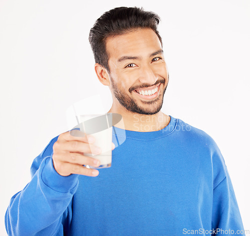 Image of Portrait, man and smile with milk in studio, white background and backdrop for healthy benefits. Asian male model, glass and calcium of smoothie, vanilla milkshake or drinking diet of dairy nutrition