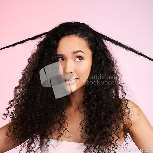 Image of Hair damage, natural beauty and confused woman with growth treatment and hairstyle problem. Cosmetics, face and female person in studio worried from shampoo care and split ends with pink background