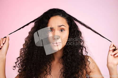 Image of Hair damage, portrait and confused woman with beauty treatment and hairstyle and problem. Cosmetics, face and female person in studio worried from shampoo care and split ends with pink background