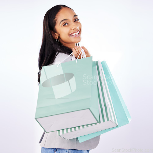 Image of Portrait, woman and bag of shopping in studio, white background and fashion deal in retail package. Happy female customer, gift bags and luxury present from mall, discount market and sales promotion