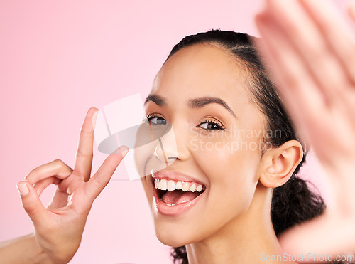 Image of Selfie, peace sign and happy woman in studio with natural beauty, wellness and cosmetics. Portrait, female person and pink background with makeup and face with skincare and emoji hand gesture of girl