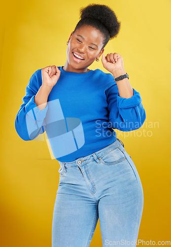 Image of Happy, dance and young woman in studio for celebration, achievement or goal with confidence. Happiness, smile and African female model moving to music, song or playlist isolated by yellow background.