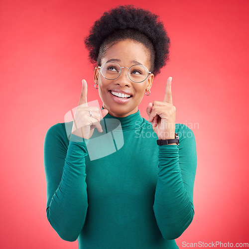 Image of Looking up, black woman and hand pointing in studio for announcement, deal or promotion on red background. Finger, smile and African female show news, sale and competition info, giveaway or vote