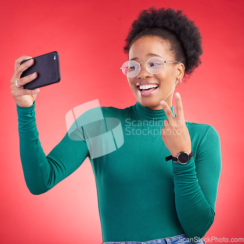 Image of Happy black woman, peace sign and selfie for photography against a red studio background. African female person or model smile for photograph, memory or social media and online post in happiness