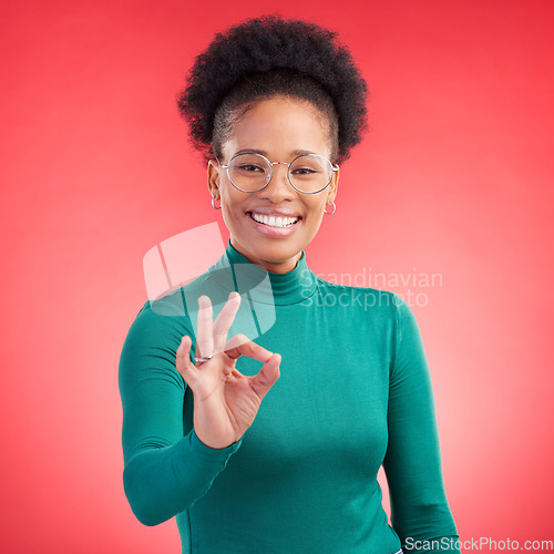 Image of Perfect, hand and happy black woman portrait in studio for support, review or success, vote or agree on red background. Smile, face and African person with okay, emoji or yes, thank you or feedback