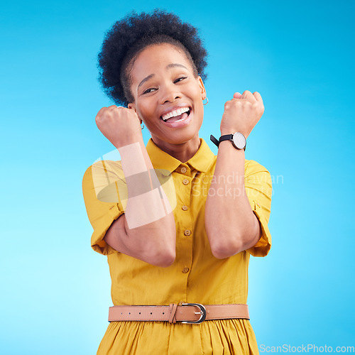 Image of Celebration, fist and happy black woman in studio for news, deal or success on blue background. Wow, hand and excited lady winner smile for sale, discount or coming soon promo, announcement or deal