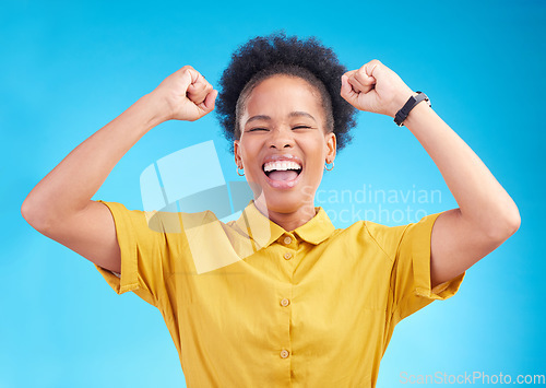 Image of Happy woman, fist pump and celebration for winning, promotion or bonus against a blue studio background. African female person enjoying victory, sale or discount in happiness for achievement or goals