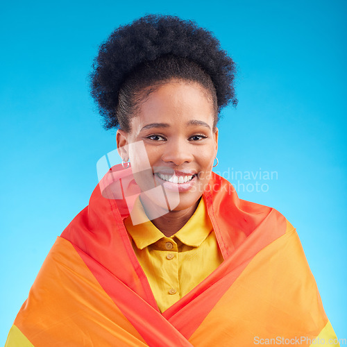 Image of Pride, flag and portrait of black woman in studio for gay, rights and lgbtq lifestyle on blue background. Rainbow, freedom and face of lesbian African female happy, smile and confident with sexuality