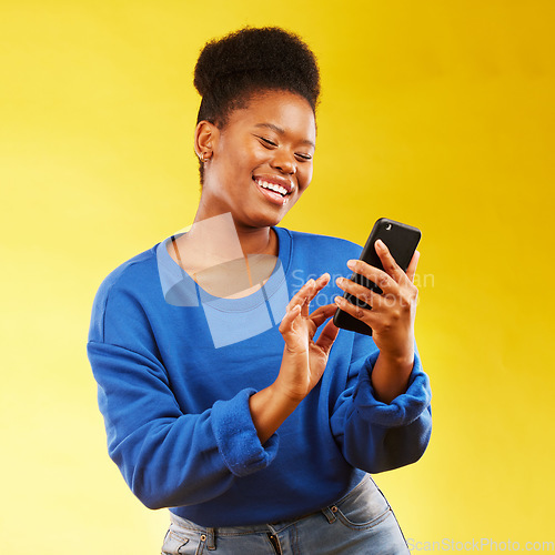 Image of Happy black woman, phone and social media for networking or communication against a yellow studio background. African female person smile for online browsing or chatting on mobile smartphone app