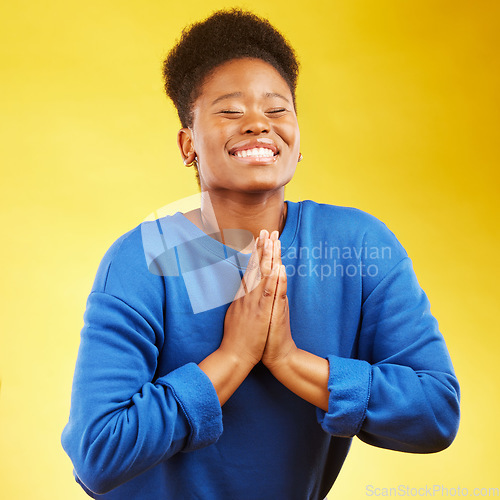 Image of Thank you, hands and black woman praying in studio happy, relief and grateful on yellow background. Blessing, gratitude and African female smile for good news, outcome or results, solution or answer