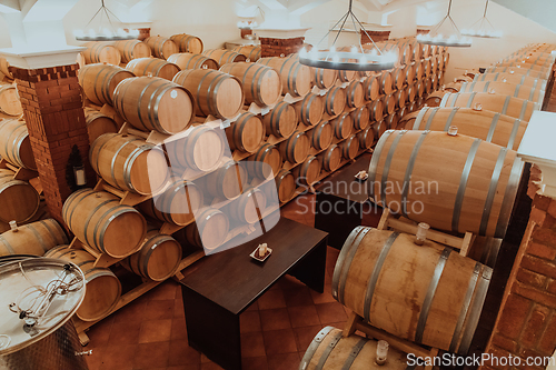 Image of Wine or cognac barrels in the cellar of the winery, Wooden wine barrels in perspective. Wine vaults.Vintage oak barrels of craft beer or brandy.