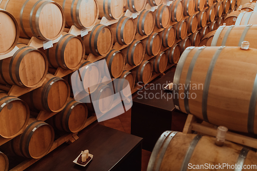 Image of Wine or cognac barrels in the cellar of the winery, Wooden wine barrels in perspective. Wine vaults.Vintage oak barrels of craft beer or brandy.