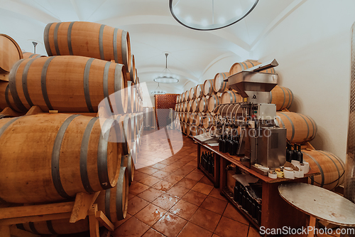 Image of Wine or cognac barrels in the cellar of the winery, Wooden wine barrels in perspective. Wine vaults.Vintage oak barrels of craft beer or brandy.