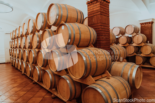 Image of Wine or cognac barrels in the cellar of the winery, Wooden wine barrels in perspective. Wine vaults.Vintage oak barrels of craft beer or brandy.