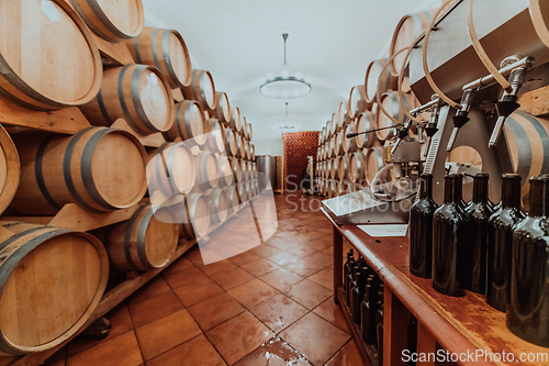 Image of Wine or cognac barrels in the cellar of the winery, Wooden wine barrels in perspective. Wine vaults.Vintage oak barrels of craft beer or brandy.