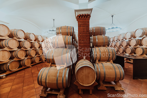 Image of Wine or cognac barrels in the cellar of the winery, Wooden wine barrels in perspective. Wine vaults.Vintage oak barrels of craft beer or brandy.