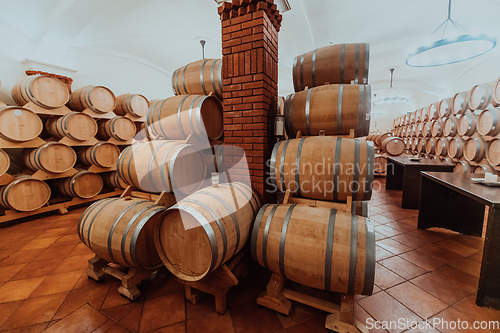 Image of Wine or cognac barrels in the cellar of the winery, Wooden wine barrels in perspective. Wine vaults.Vintage oak barrels of craft beer or brandy.