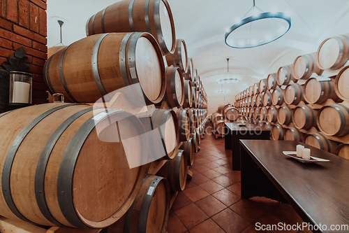 Image of Wine or cognac barrels in the cellar of the winery, Wooden wine barrels in perspective. Wine vaults.Vintage oak barrels of craft beer or brandy.