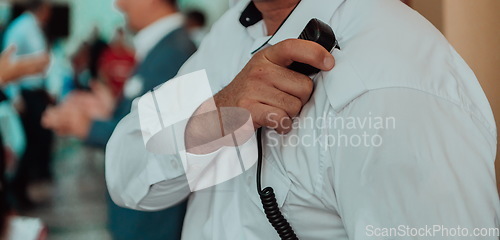 Image of A close-up photo of a guard holding a communication device