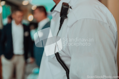 Image of A close-up photo of a guard holding a communication device