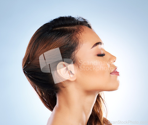 Image of Woman, hair care or profile of skincare for beauty, wellness or cosmetics in studio on blue background. Natural hairstyle, girl or model in facial treatment for healthy glowing skin or dermatology