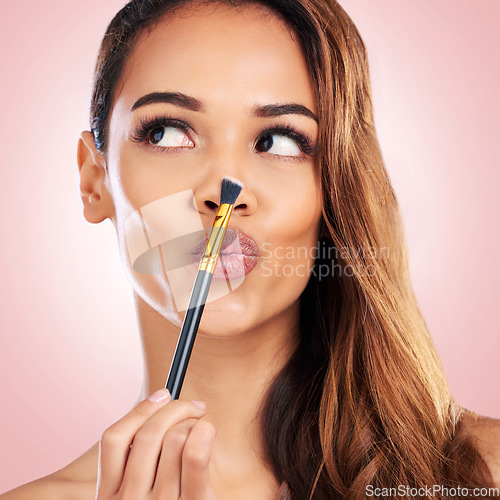 Image of Beauty, pout and face of woman with makeup brush on pink background for salon, wellness and luxury. Cosmetology, aesthetic and female person with tools for foundation, cosmetics and glamour in studio