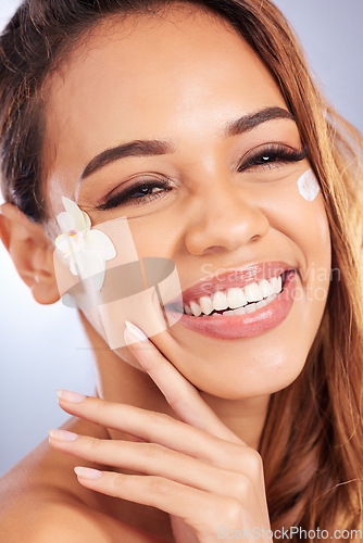 Image of Cosmetics, portrait of happy woman with flower and cream on face, natural makeup and spa treatment on white background. Skincare, beauty and smile, model with floral and organic facial care in studio