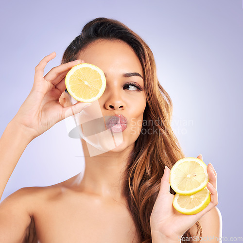 Image of Citrus, lemon and eye of woman with beauty, natural or organic wellness isolated in a purple studio background. Excited, happy and healthy young female person with vitamin c for skincare or detox