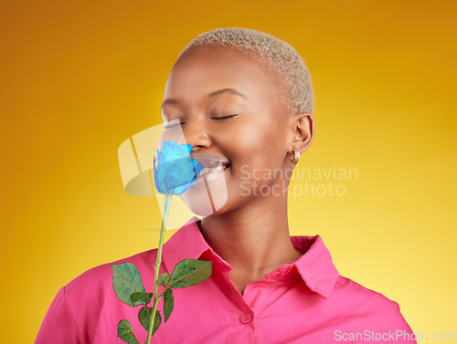 Image of Smelling, love and spring with black woman and rose in studio for blossom, plant and environment. Gift, love and blue flower with face of person on yellow background for floral, scent and mockup