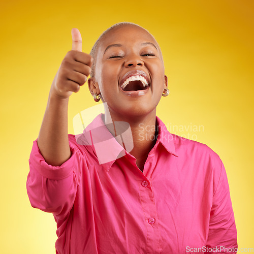 Image of Laughing, black woman and thumbs up in studio for vote, review or positive feedback on yellow background. Yes, hand and happy African female with emoji for choice, thank you or decision support