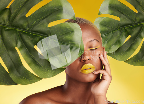 Image of Calm black woman, makeup and leaves in skincare for natural beauty or cosmetics against a yellow studio background. Face of African female person in relax for facial treatment, lipstick or product