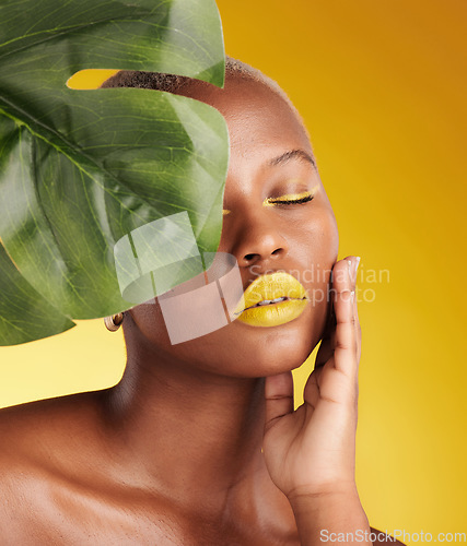 Image of Beauty, makeup and leaf with face of black woman in studio for tropical, natural and cosmetics. Luxury, sustainability and health with female model on yellow background for plant, salon and wellness